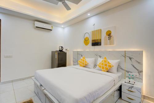 a bedroom with a large white bed with orange pillows at The Empire Studioz Hotel Golf Course Road Studio with Kitchen & Balcony One Horizon Center Paras Hospital Cyber City in Gurgaon