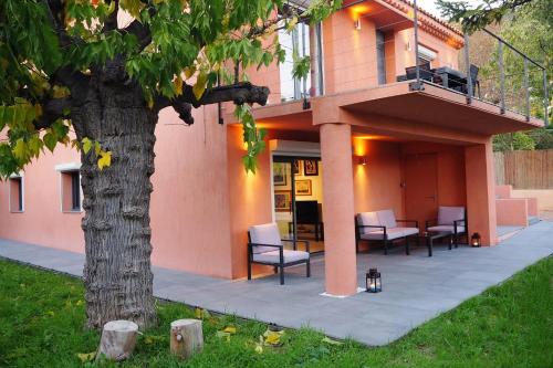 une maison avec une terrasse couverte dotée de chaises et d'un arbre dans l'établissement Madehouse - T3 indépendant-Parking-Piscine-Centre ville Aix à pied, à Aix-en-Provence