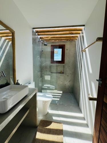 a bathroom with a sink and a toilet at Casa Calango suites in Fortim