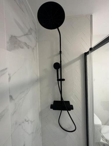 La salle de bains est pourvue d'une douche avec un pommeau de douche noir. dans l'établissement PARIS CDG Superbe appartement en résidence, à Villepinte