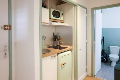 une petite cuisine avec un évier et un micro-ondes dans l'établissement WiFi AC 5 mins from the Croisette, au Cannet