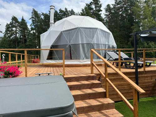 a yurt on a deck with a table and benches at Grisli glempings in Gauja