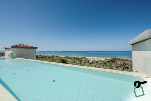 a swimming pool with a view of the ocean at HOTIDAY Room Collection - Tirrenia in Tirrenia
