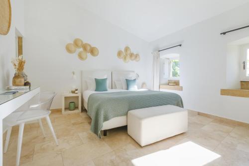 a white bedroom with a bed and a white desk at Le Vieux Castillon in Castillon-du-Gard