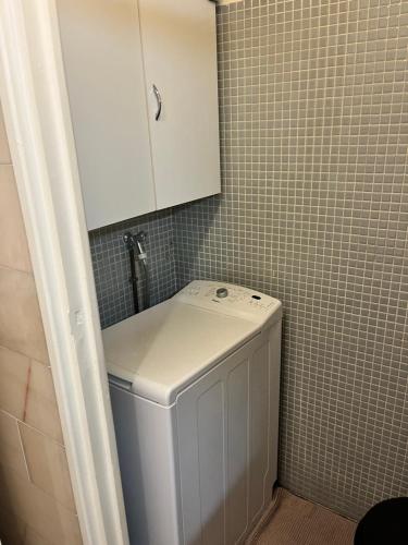 - un lave-linge dans la salle de bains pourvue d'une armoire blanche dans l'établissement Agréable appartement climatisé devant la mer avec parking, à Antibes