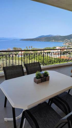 a white table and chairs with a view of the ocean at Althea Dream Summer House in Marmarion
