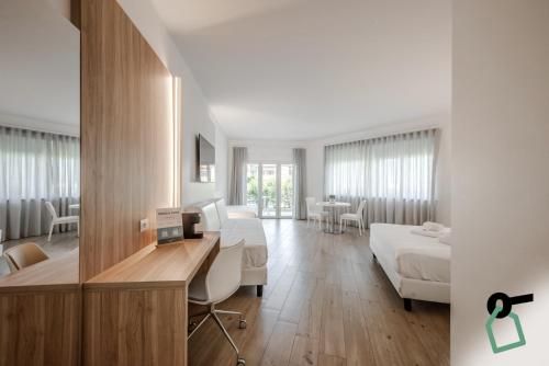 a bedroom with a bed and a desk with a computer at HOTIDAY Room Collection - Tirrenia in Tirrenia