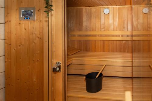a wooden sauna with a black bucket in it at Villa am Wehr in Allersberg