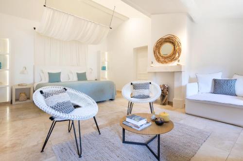 a living room with two chairs and a bed at Le Vieux Castillon in Castillon-du-Gard