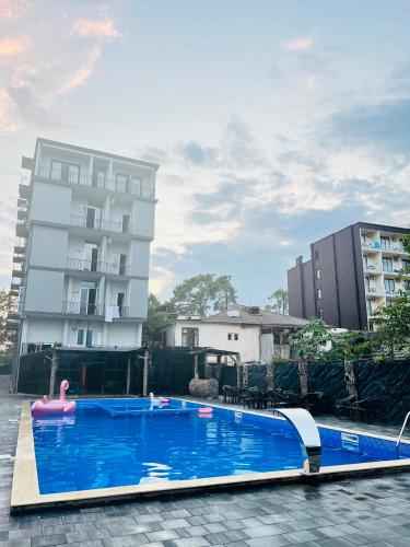 a swimming pool in front of a building at Grand Hotel Kobuleti in K'obulet'i