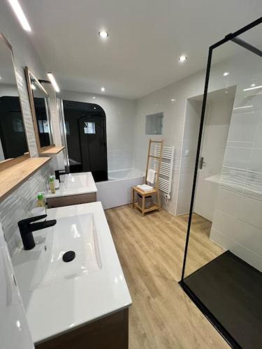 une salle de bain avec deux lavabos et une baignoire dans l'établissement Chez Hugo, à Saint-Brice-Courcelles