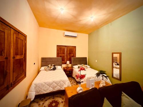 a room with two beds and a table with flowers at Casa Villa Antigua in Montemorelos