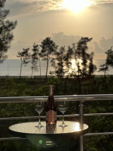 a bottle of wine sitting on a table with two glasses at Grand Hotel Kobuleti in K'obulet'i