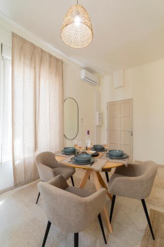 une salle à manger avec une table et des chaises en bois dans l'établissement le Nîmois Appart Clim MaisonCarréeConciergerie, à Nîmes