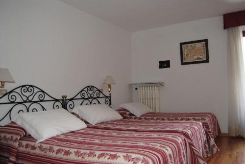 a bedroom with two beds with red and white sheets at Centrale in Courmayeur