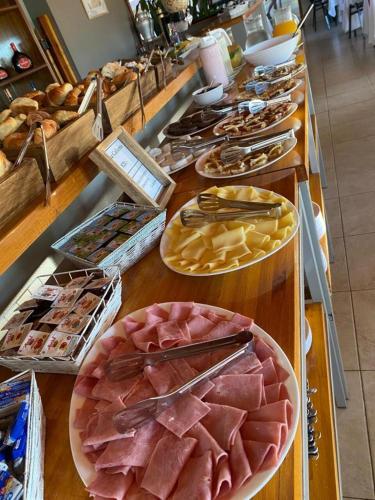 a buffet line with different types of meats and cheese at Club Valle Termal Resort in Federación