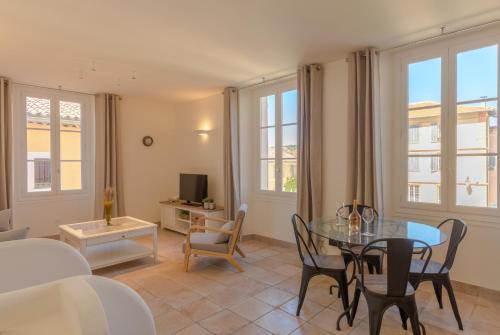 un salon avec une table en verre et des chaises dans l'établissement VALBONNE Maison cœur de village, à Valbonne