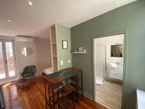 a living room with a table and a room with a bathroom at Studio terrasse avec entrée spa incl -proximité Le PAL in Bourbon-Lancy