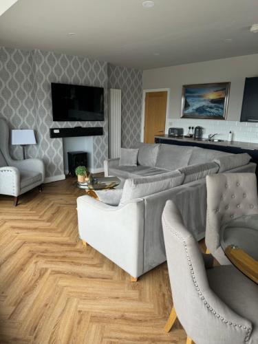 a living room with a couch and chairs and a fireplace at Beach House Apartment on ground floor with sea view - pet friendly in Cleveleys