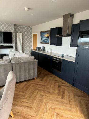 a living room with a couch and a kitchen at Beach House Apartment on ground floor with sea view - pet friendly in Cleveleys