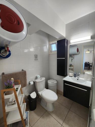 a small bathroom with a toilet and a sink at Ocean Pearl in Peyia