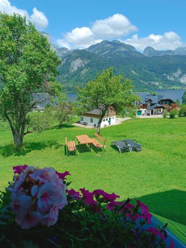 a park with benches and a lake and mountains at Ferienhaus Christern in Grundlsee