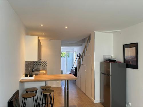 La cuisine est équipée d'un comptoir avec tabourets et d'un réfrigérateur. dans l'établissement Welcome sur le Bassin, à La Teste-de-Buch