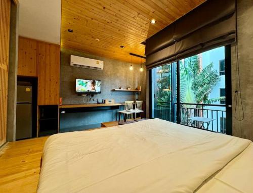 a bedroom with a large bed and a balcony at Taya NaiHarn, Scenic View, Modern Studio, Relife Windy in Rawai Beach