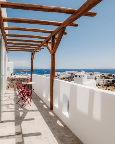 a balcony with a table and chairs overlooking the ocean at Pelican Bay Hotel in Platis Yialos Mykonos