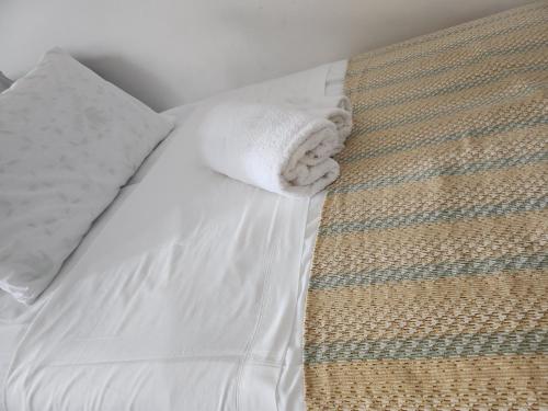 a bed with a white towel laying on it at House Arrow in Latina