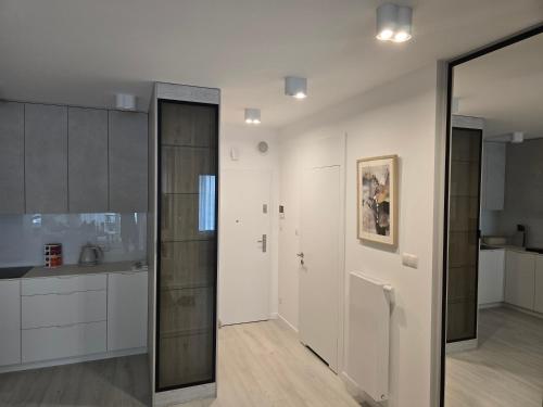 ロゴボにあるApartamenty Rogowo Pearlの白いキャビネットと大きな鏡付きのキッチン
