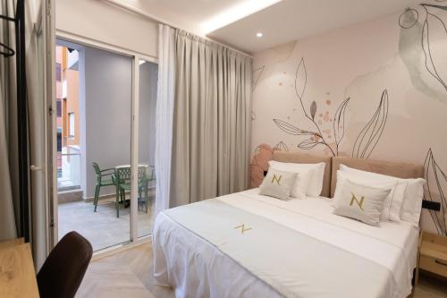 a bedroom with a bed with white sheets at Nayel Hotel in Durrës