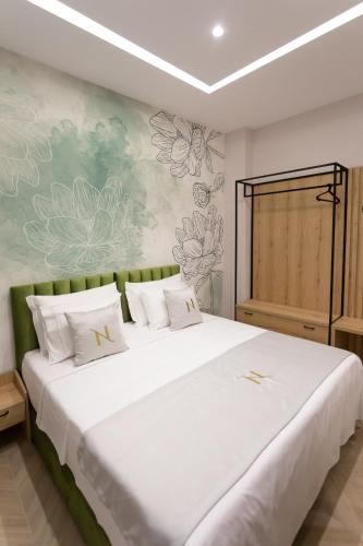 a bedroom with a large white bed with white pillows at Nayel Hotel in Durrës