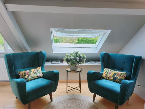 two blue chairs in a room with a window at Suite familiale "Le Logis des Ptits Lynx" in Montain