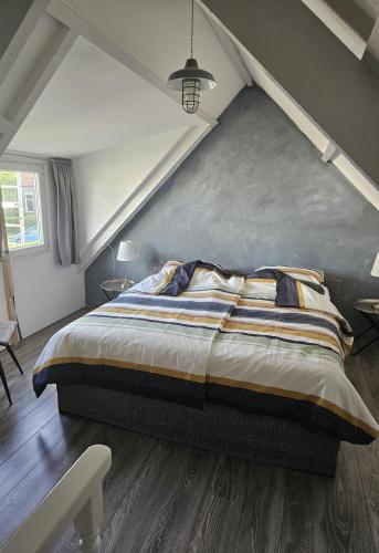 a bedroom with a large bed in a attic at Witte Magnolia in Burgh Haamstede