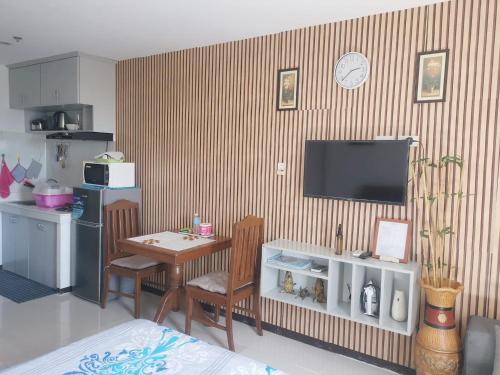 a living room with a table and a television on a wall at Unit 1109 Cityscape Residences in Bacolod