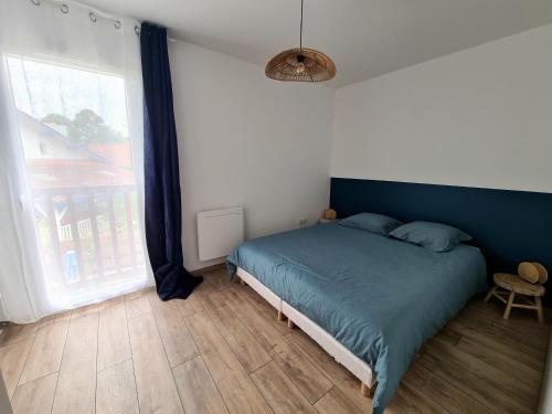 a bedroom with a bed and a large window at Maison Marsane côte Landaise in Lit-et-Mixe