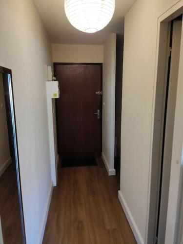 un couloir avec une porte marron et du parquet. dans l'établissement Studio, à La Grande Motte