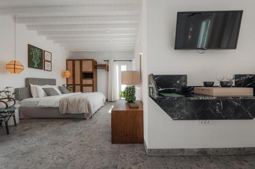 a bedroom with a bed and a tv on a wall at Pelican Bay Hotel in Platis Yialos Mykonos