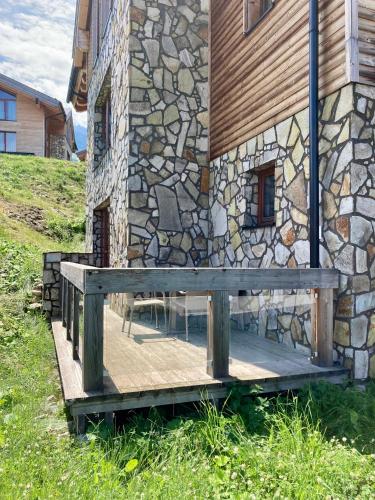 a wooden bench sitting outside of a stone building at Apartment Jasná Otupné in Demanovska Dolina