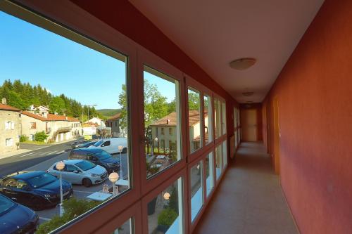 a hallway with windows and a view of a parking lot at Logis Hotel Spa Restaurant Le Provence in Lanarce