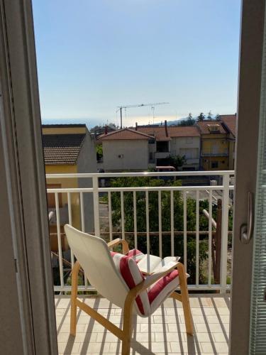 a chair on a balcony with a view of a city at Central Petacciato-Guest House in Petacciato