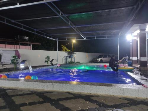 a swimming pool at night with a person playing in it at Nel Homestay 1 with BIG Private Pool at Kota Bharu in Kota Bharu