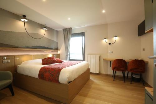 a bedroom with a bed and a table and chairs at Logis Hotel Spa Restaurant Le Provence in Lanarce
