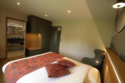 a bedroom with a bed with two pillows on it at Logis Hotel Spa Restaurant Le Provence in Lanarce