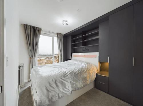 a bedroom with a large bed and a window at Luxury & Bright Apartment-Near Tube & Shops -Gym Access in Hatch End