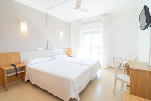 a bedroom with two beds and a desk and a tv at Hotel La Terraza in Sanxenxo