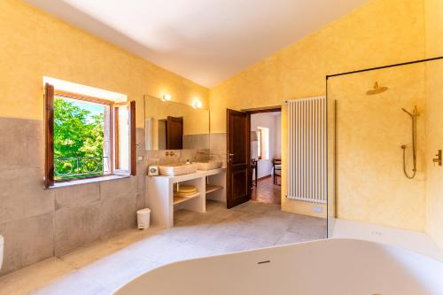 a bathroom with a tub and a sink and a mirror at Luxury Villa Tre Querce W View - Private e Relaxing Location under stars in Ulignano