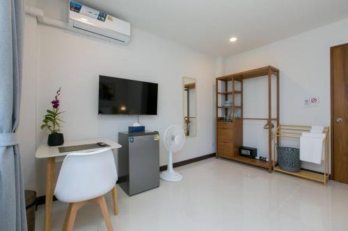 a white room with a desk and a tv on the wall at Wow Academy & Stay Soi Tai-Aed 2A in Ban Suan