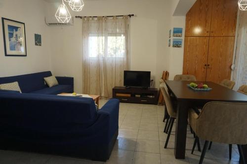 a living room with a blue couch and a table at Nicholas Waves Beach Studios in Lardos